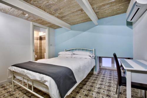 a blue bedroom with a bed and a desk at Chateau La Vallette - L-Ghorfa Suite in Valletta