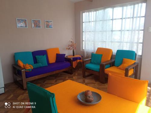 sala de estar con sillas coloridas y mesa en Rinconcito Andino II, en La Paz