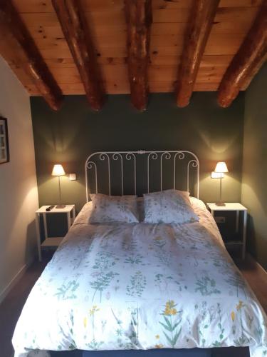 a bed in a bedroom with two lamps on tables at Casa CARMA in Campillo de Ranas