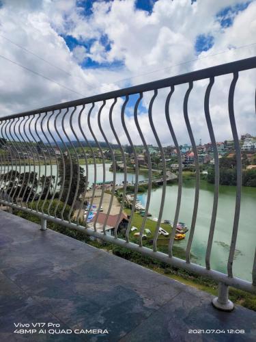 a metal bridge over a river with a body of water at Misty Paradise of Lake Gregory in Nuwara Eliya