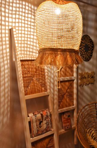 a wicker chair with a light on top of it at Angelos Design Suites in Patitiri