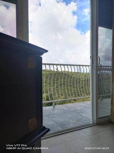 a door to a balcony with a view of a vineyard at Misty Paradise of Lake Gregory in Nuwara Eliya