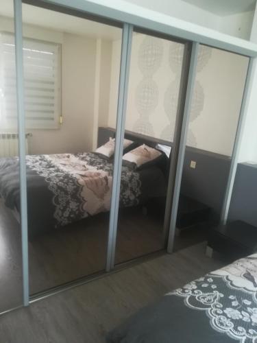 a bedroom with a bed and a reflection in mirrors at Logement de plein pied à MIRECOURT in Mirecourt
