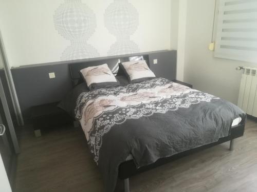 a bedroom with a bed with two pillows on it at Logement de plein pied à MIRECOURT in Mirecourt