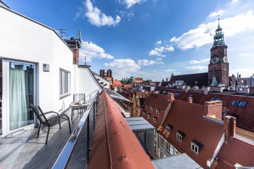 a balcony with a view of a city with a clock tower at Aparthotel New Lux in Wrocław