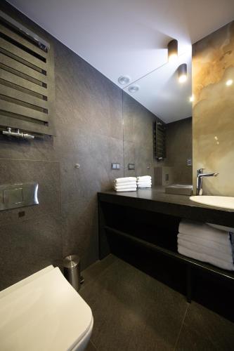 a bathroom with a white toilet and a sink at Aparthotel New Lux in Wrocław