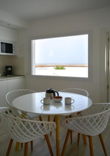 a white table and chairs in a kitchen with a window at Island Home Fuerteventura in Corralejo