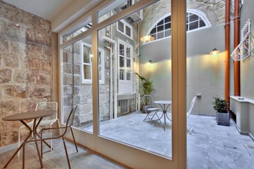 Cette chambre comprend une fenêtre, une table et des chaises. dans l'établissement Chateau La Vallette - Barrakka Suite, à La Valette