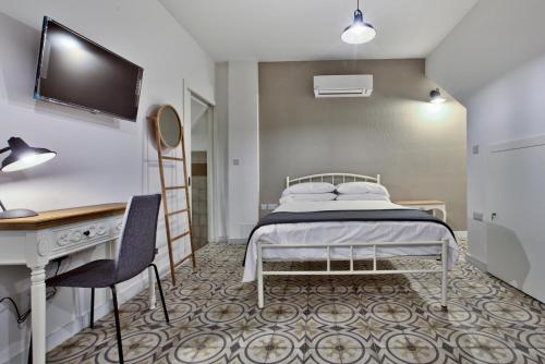 a bedroom with a bed and a desk and a computer at Chateau La Vallette - Barrakka Suite in Valletta