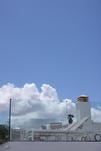 a white building with clouds in the sky at Island Home Fuerteventura in Corralejo