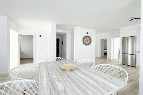 a white dining room with a table and chairs at Island Home Fuerteventura in Corralejo
