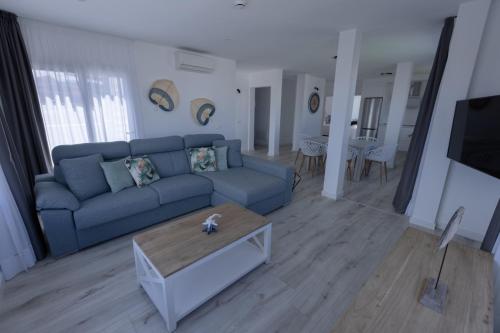a living room with a blue couch and a coffee table at Island Home Fuerteventura in Corralejo