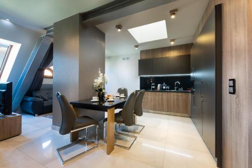 a kitchen and dining room with a table and chairs at Aparthotel New Lux in Wrocław