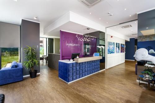 a lobby of an office with a purple reception desk at Impresamente Art Hotel in Sofia