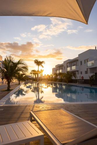 a view of a swimming pool at sunset at Island Home Fuerteventura in Corralejo