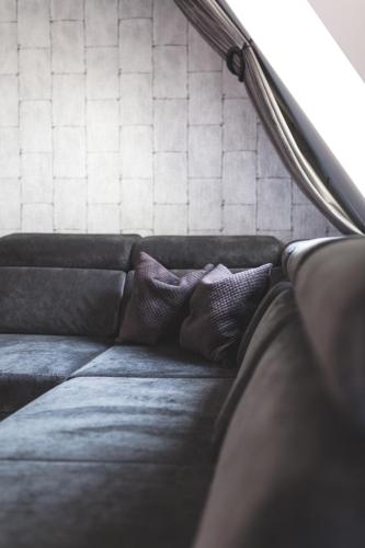a couch with two pillows on top of it at Aparthotel New Lux in Wrocław