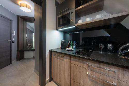 a kitchen with wooden cabinets and a black counter top at Aparthotel New Lux in Wrocław