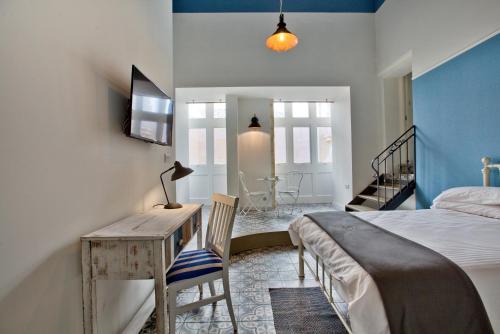 a bedroom with a bed and a desk with a lamp at Chateau La Vallette - Grand Master's Suite in Valletta