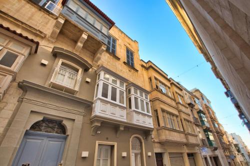 a building with white windows and a blue door at Chateau La Vallette - Grand Master's Suite in Valletta