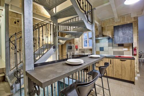 a kitchen with a long counter with stools at Chateau La Vallette - Grand Master's Suite in Valletta