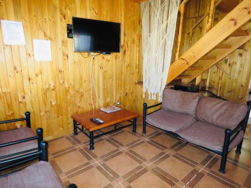 a living room with a couch and a tv and a table at La Estrella del canelo in Algarrobo