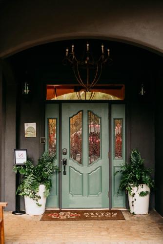 a green door with two potted plants in front of it at Sylvan Valley Lodge and Cellars in Sautee Nacoochee