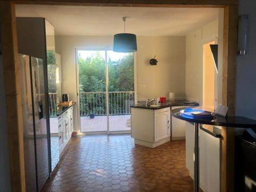 - une cuisine avec vue sur un balcon dans l'établissement Condrieu idéal pour découvrir le Pilât parking voiture vélo inclus, à Condrieu