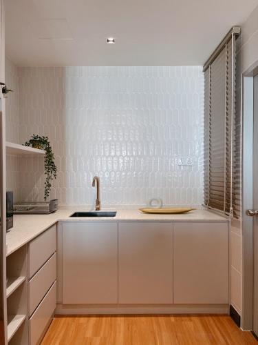 a kitchen with white cabinets and a sink at SURAI Homes - Sea View, Drawbridge & KTCC Mall in Kuala Terengganu