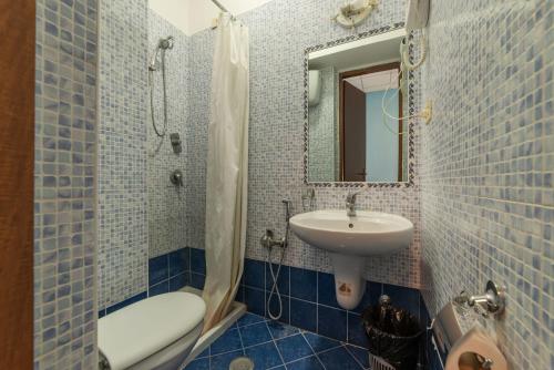 a blue tiled bathroom with a sink and a shower at Hotel Beauty Palace - Vertex Group in Rome