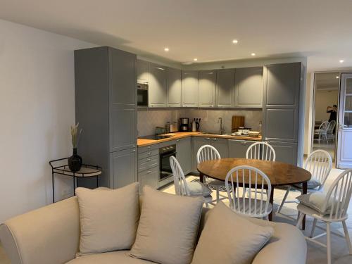 uma sala de estar com um sofá, uma mesa e uma cozinha em Les hauts de campagne em La neuville roy