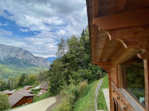 a house with a window looking out at the mountains at Chalet Alpilles - Chalet familial, récent, tout équipé in Chamoson