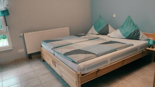 a bedroom with a large bed with blue pillows at Ferienwohnung am Waldrand in Herdwangen-Schönach