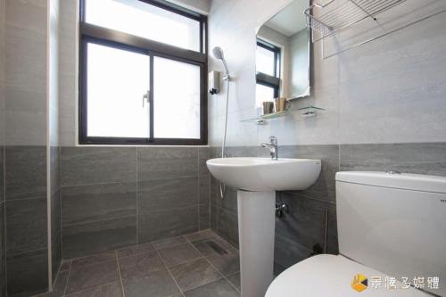 a bathroom with a sink and a toilet and a window at Hua Ge B&B in Wujie