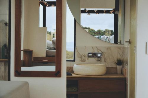 a bathroom with a sink and a mirror at Hush Maderas in San Juan del Sur