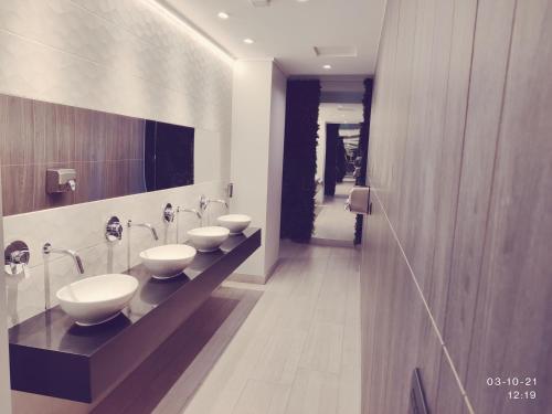 uma casa de banho com quatro lavatórios e uma fila de espelhos em Departamento de primer Nivel em Chillán