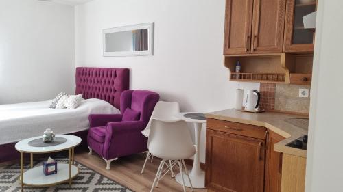 um quarto de hotel com uma cama e uma cadeira roxa em Vlašićka idila apartman Eko Fis 507 em Vlasic