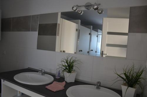 a bathroom with two sinks and a large mirror at Pokoje Kalisz in Kalisz