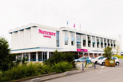 a large white building with cars parked in a parking lot at Mercure Nevers Pont De Loire in Nevers