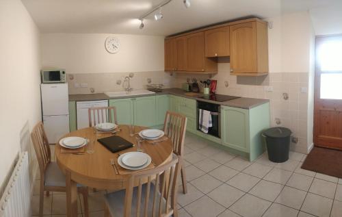 a kitchen with a wooden table with chairs and a table and a table at Marsland Cottage in Bideford