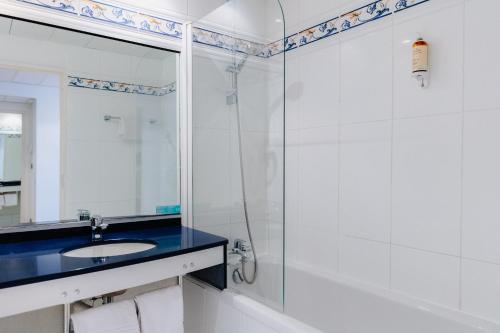 a bathroom with a shower and a sink and a mirror at Mercure Nevers Pont De Loire in Nevers