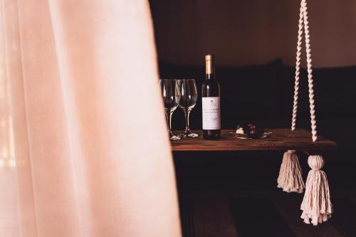 a bottle of wine and glasses on a wooden shelf at Dakota forest retreat in Tsigov Chark