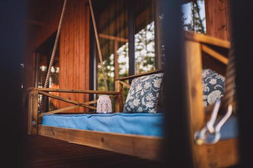 a swing in a room with blue sheets and pillows at Dakota forest retreat in Tsigov Chark