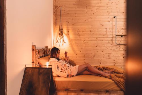 a woman sitting on a bed in a room at Dakota forest retreat in Tsigov Chark