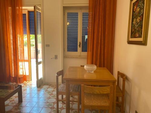 a dining room with a wooden table and chairs at Villa conchilglia - 30 metri dal mare in Lido Conchiglie