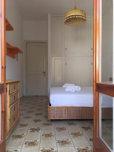 a bedroom with a bed and a dresser with towels on it at Villa conchilglia - 30 metri dal mare in Lido Conchiglie