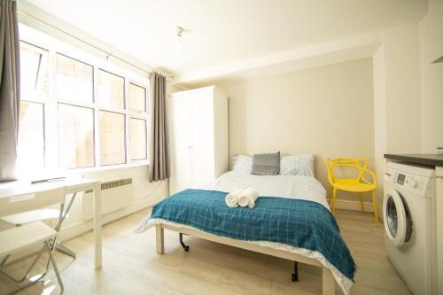 a bedroom with a bed with a towel on it at X Farringdon Apartments in London