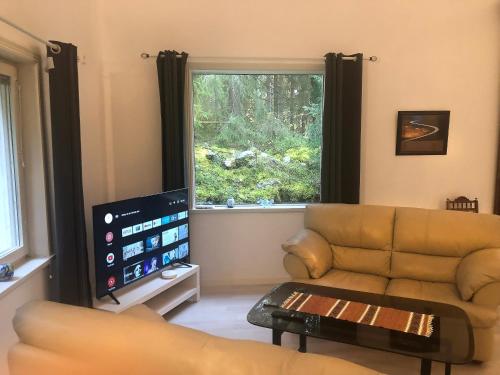 a living room with a couch and a large window at Granbackens BoB in Falun