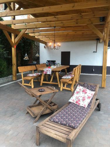 a patio with a table and chairs under a wooden roof at Villa Rynek in Góra Świętej Anny