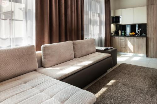 a living room with a couch and a kitchen at Aparthotel New Lux in Wrocław