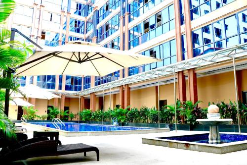 an umbrella in front of a building with a pool at Le Chen Miiya Hotel in Sihanoukville